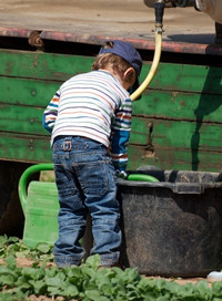 Foto kleiner Junge am Wassertank